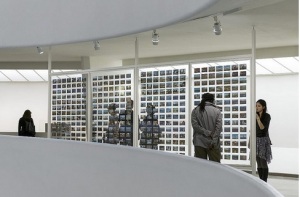 Viewers peruse a fraction of the 1,800 postcards that On Kawara sent to document the time he got up at various cities in his travels. Photo by David Heald